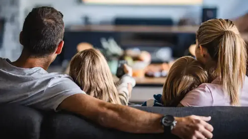 IPTV Anbieter FAQ: Familie schaut gemeinsam fern und klärt Fragen zum Abo
